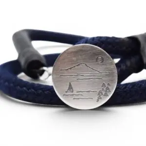 armband med blå tamp och silverbricka med bild