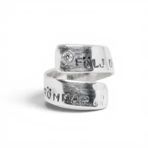 handgjord silverring i spiralform med text och en sten