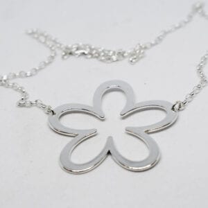 silverhalsband i form av enstor blomma på vit bakgrund