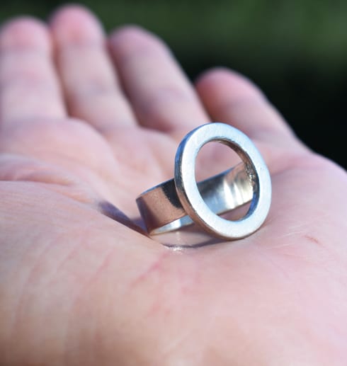 silverring i form av en rund ring i handflata utomhus