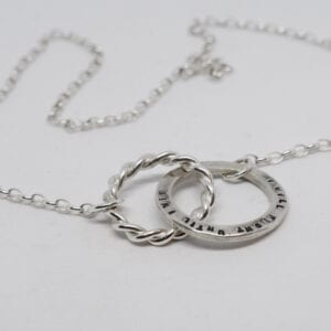 silverhalsband med text på vit botten
