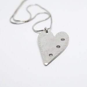 silverhjärta med stenar på vit bakgrund