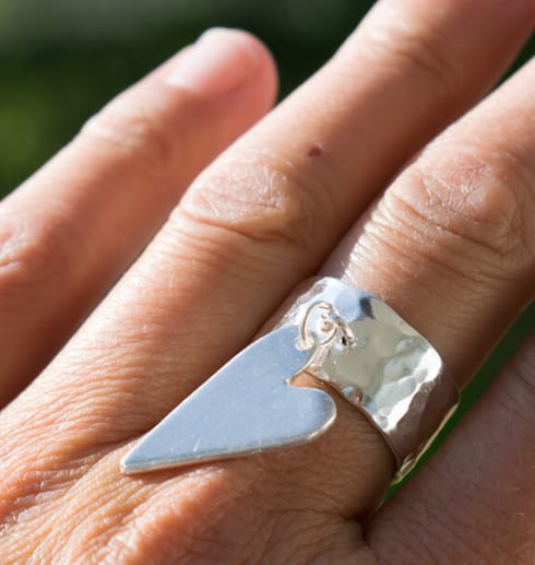 silverring med löst hängande ring på finger utomhus