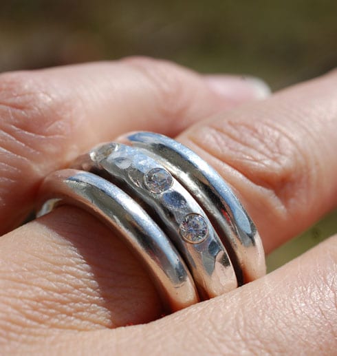 tre grova silverringar på finger utomhus