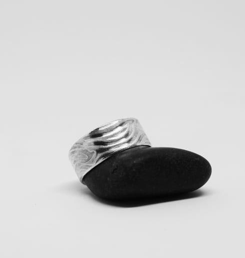 mönstrad silverring på svart sten med vit bakgrund