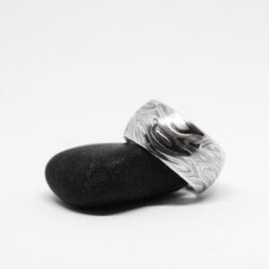 silverring med mösnter på svart sten med vit bakgrund
