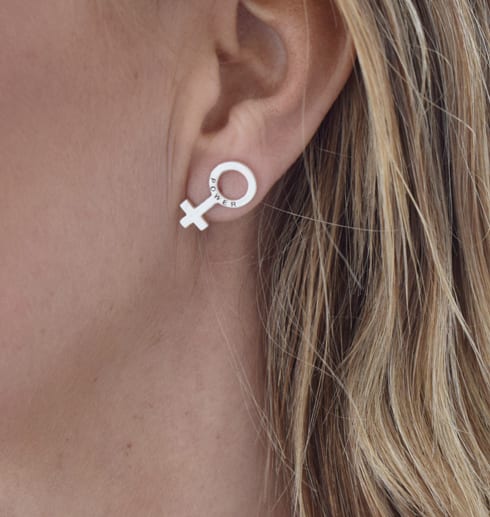 silverörhängen i form av kvinnosymbolen på öra på kvinna utomhus