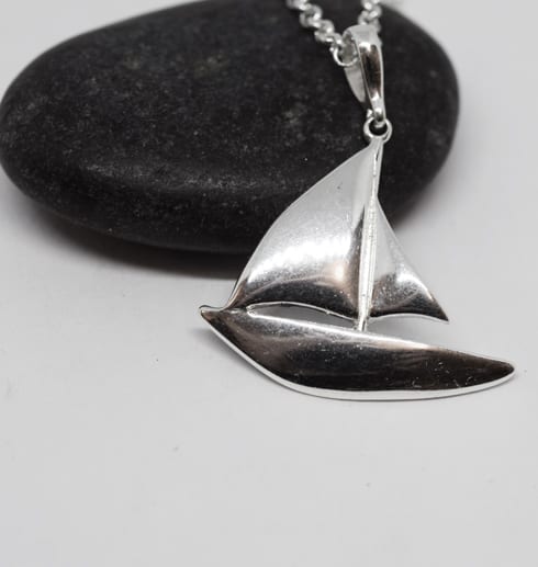 halsband i form av en segelbåt i silver mot svart sten