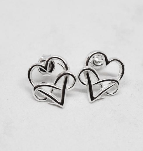 silverörhängen i form av hjärtan med evighetssymbol på vit bakgrund