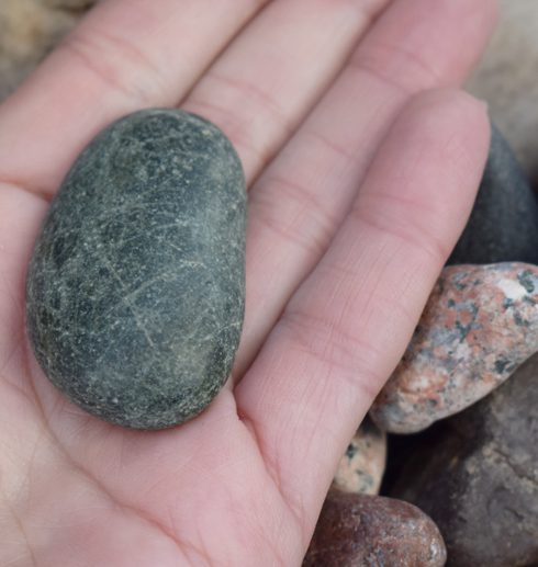 grå sten i kvinnas hand utomhus