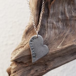 silverhjärta med texten starkskör på trädgren utomhus