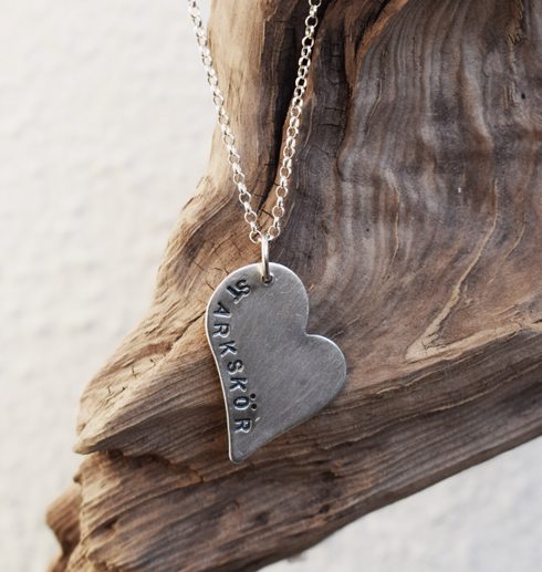 silverhjärta med texten starkskör på trädgren utomhus