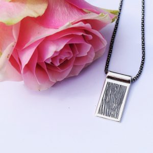 Herrhalsband med struktur och svartoxidering vid rosa ros