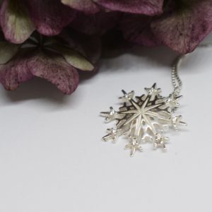 snöflinga i silver med lila blomma bakom