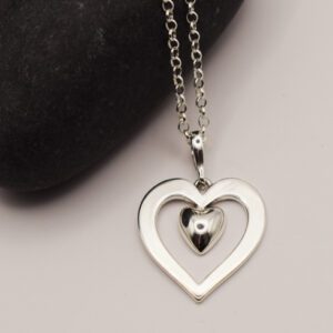 silverhjärta i kedja med svart sten bredvid