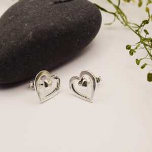 silverörhängen i form av hjärtan med sten och grön kvist bredvid