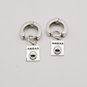 silverörhängen med texten ANDAS på vit bakgrund