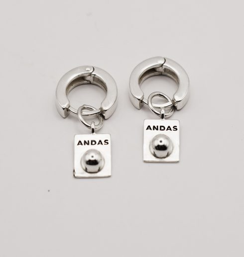 silverörhängen med texten ANDAS på vit bakgrund