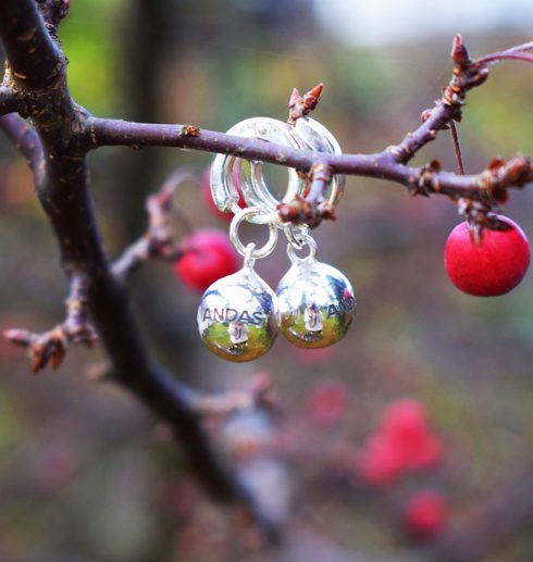 silverörhängen i form av bollar i trädgren utomhus