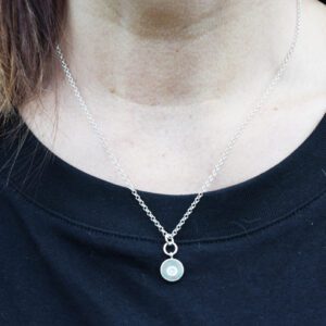 silverhalsband med sten i mitten på kvinna