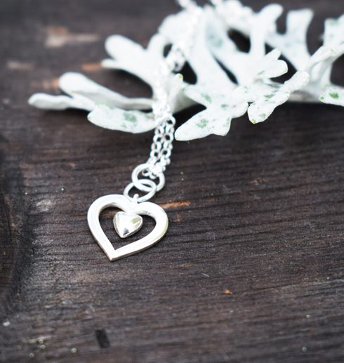 silverhjärta med ett silverfärgat blad bredvid